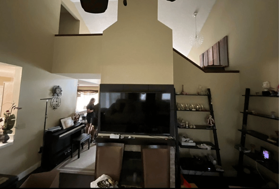 Living room fireplace and TV wall before renovation by Guardian Shield Windows & Doors