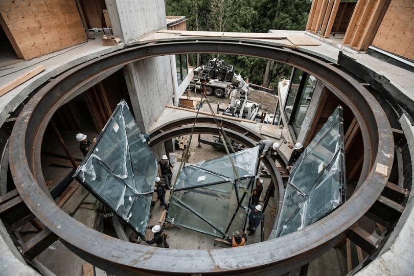 Construction site of a modern luxury home requiring custom-cut geometric glass panels